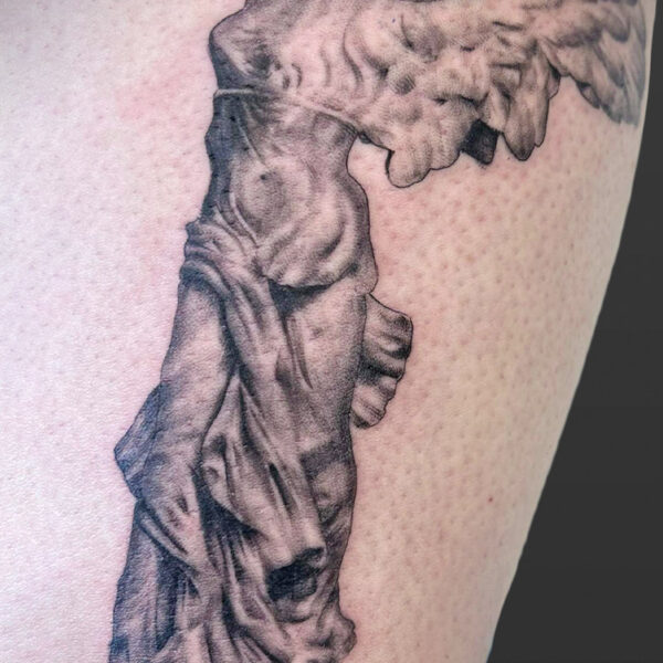 Atticus Tattoo| Black and grey, realism tattoo of a statue of a robed woman with wings instead of arms