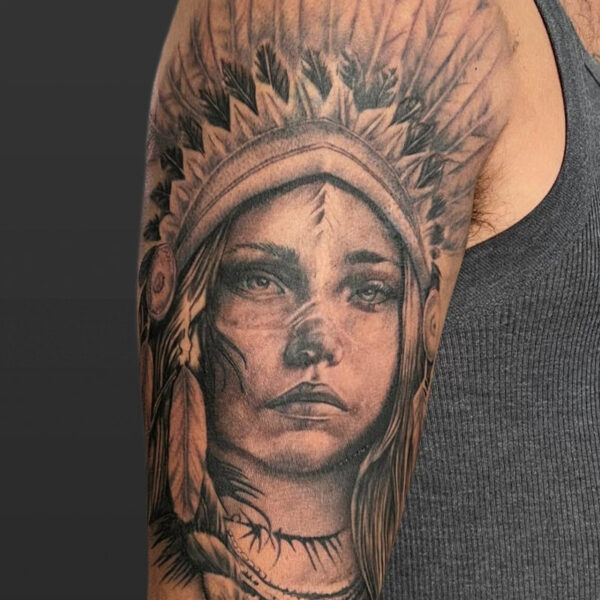 Atticus Tattoo| Black and grey, realism tattoo of a woman with a headdress
