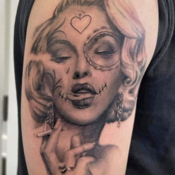 Atticus Tattoo| Black and grey, realism tattoo of Marilyn Monroe smoking a cigarette with sugar skull markings