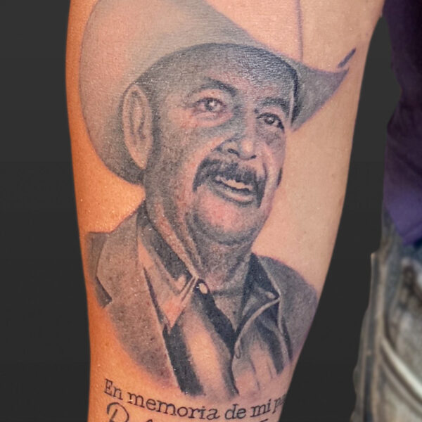 Atticus Tattoo| Black and grey, realism tattoo of a memorial of a man with a moustache and cowboy hat