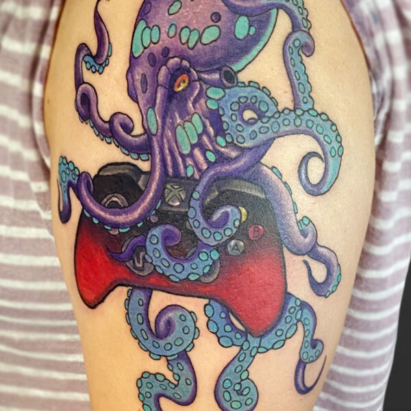 Atticus attoo| Coloured tattoo of a purple and blue octopus holding a red, xbox game controller