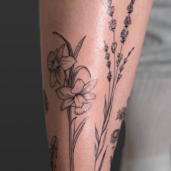 Atticus Tattoo| Fine line tattoo of daffodils and stem of small flowers