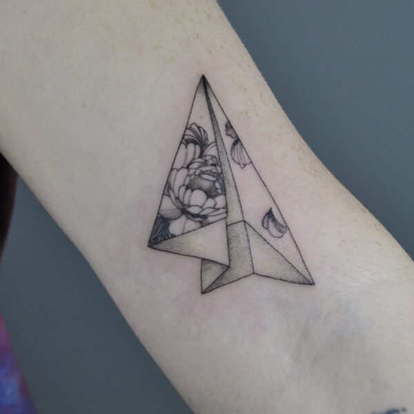 Atticus Tattoo| Fine line tattoo of an origami paper airplane with flowers