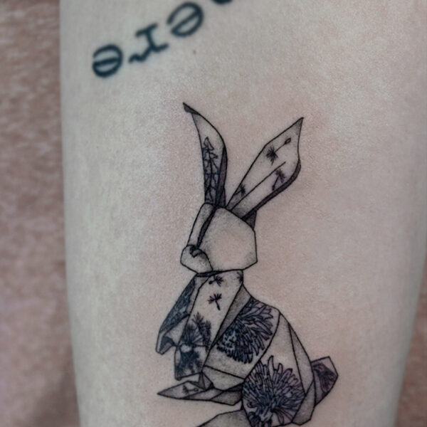 Atticus Tattoo| Fine line tattoo of an origami rabbit with flowers