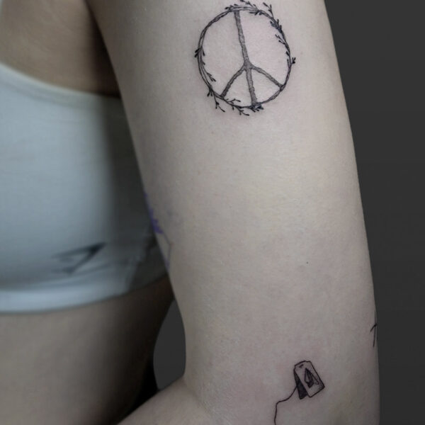 Atticus Tattoo| Fine line tattoo of a peace symbol made out of twigs