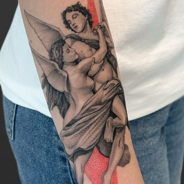 Atticus Tattoo| Black and grey, realism tattoo of a man and woman with wings, embracing, and red triangles behind them