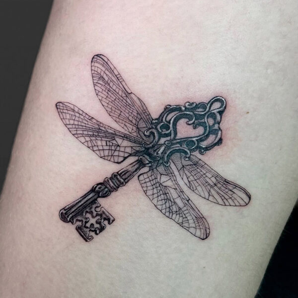 Atticus Tattoo| Black and grey tattoo of a vintage key with dragonfly wings