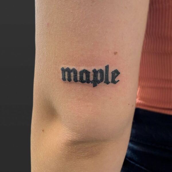 Atticus Tattoo| Blackwork, script tattoo of the word "Maple"