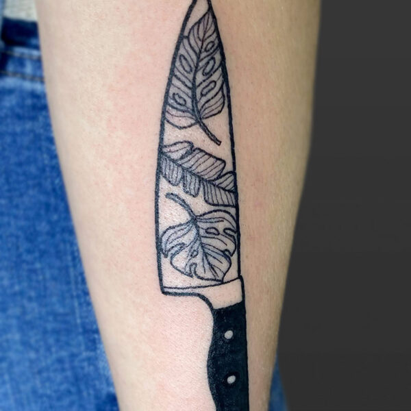 Atticus Tattoo| Blackwork tattoo of kitchen knife with monstera leaves in the blade