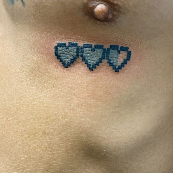 Atticus Tattoo| Tattoo of three blue, pixelated hearts, one that is half-full