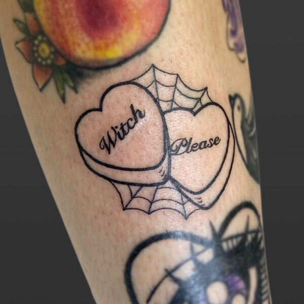 Atticus Tattoo| American traditional tattoo of two candy hearts, spiderwebs and the words "Witch Please"