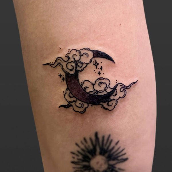 Atticus Tattoo| Black and grey tattoo of a crescent moon with clouds and stars