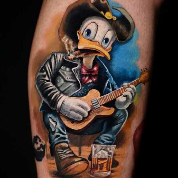 Atticus Tattoo| Cartoon tattoo of Donald Duck wearing a cowboy hat, leather jacket and playing guitar