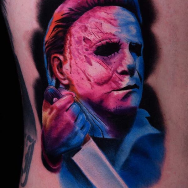 Atticus Tattoo| Colour realism tattoo of Michael Meyers holding a knife, with pink and blue inks