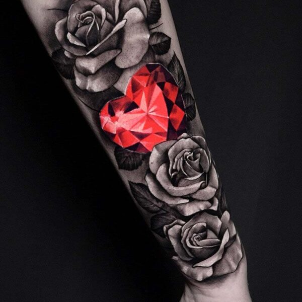 Atticus Tattoo| Black and grey realism tattoo of three roses and red, heart shaped diamind