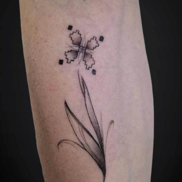 Atticus Tattoo| Black and grey tattoo of a flower stem with an abstract flower and semi-realism leaves