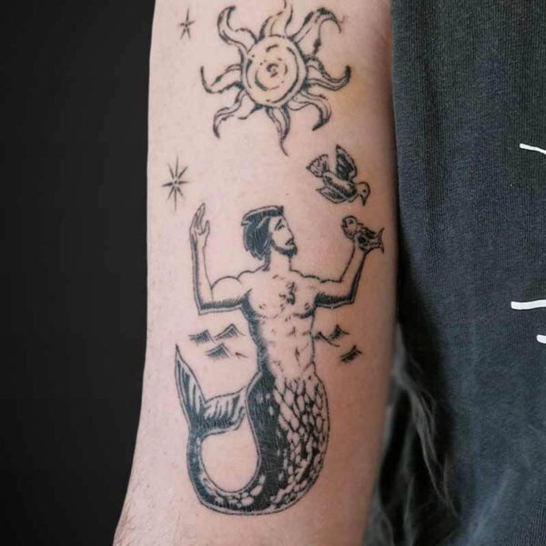 Atticus Tattoo| Illustrative Tattoo of a merman with birds, the sun and stars