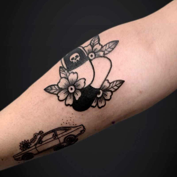Blackwork Tattoo- Pills and Flowers Atticus Tattoo| Blackwork tattoo| American traditional tattoo of two pills and flowers