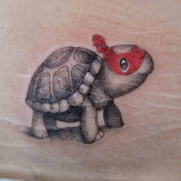 Atticus Tattoo| Black and grey tattoos| cartoon tattoo| Black and grey tattoo of a small, cartoon turtle with a red ninja scarf