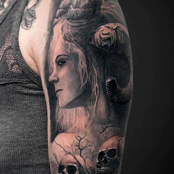 Black and Grey Realism Tattoo- Demon Woman Atticus Tattoo| Black and grey realism tattoo of a demon woman with horns and skulls in the foreground