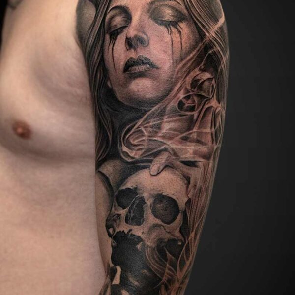 Black and Grey Realism Tattoo- Demon and Skull Atticus Tattoo| Black and grey realism tattoo of a demon woman holding a skull with smoke swirling around