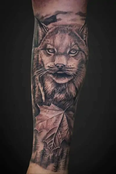 Atticus Tattoo| Black and grey realism tattoo of a lynx and maple leaf