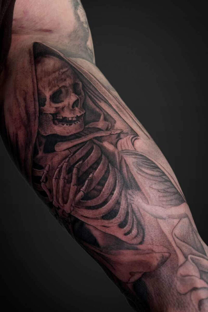 Atticus Tattoo| Black and grey realism tattoo of a skeleton in a cloak
