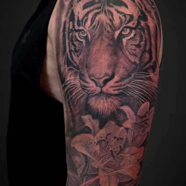 Black and Grey Realism Tattoo- Tiger Lilies Atticus Tattoo| Black and grey realism tattoo of a tiger with lilies