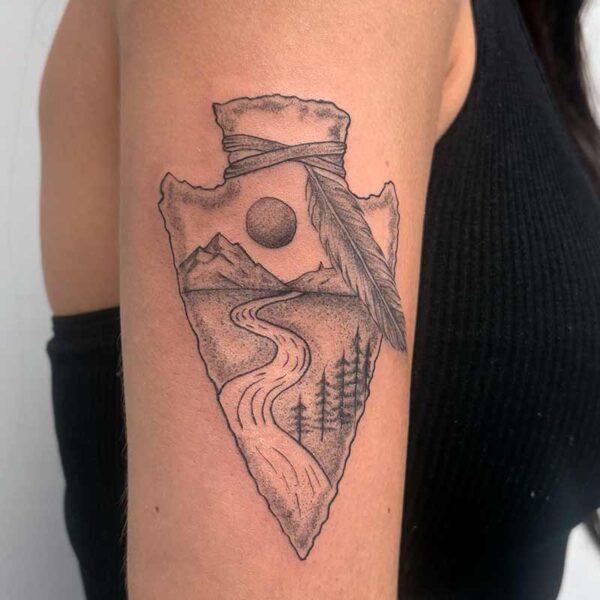 Black and Grey Tattoo- Arrowhead Atticus Tattoo| Black and grey tattoo of an arrowhead with a mountain scene inside it