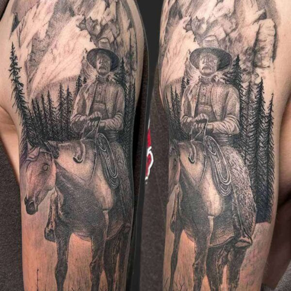 Black and Grey Realism Tattoo- Cowboy Atticus Tattoo| Black and grey realism tattoo of a cowboy on a horse in the mountains