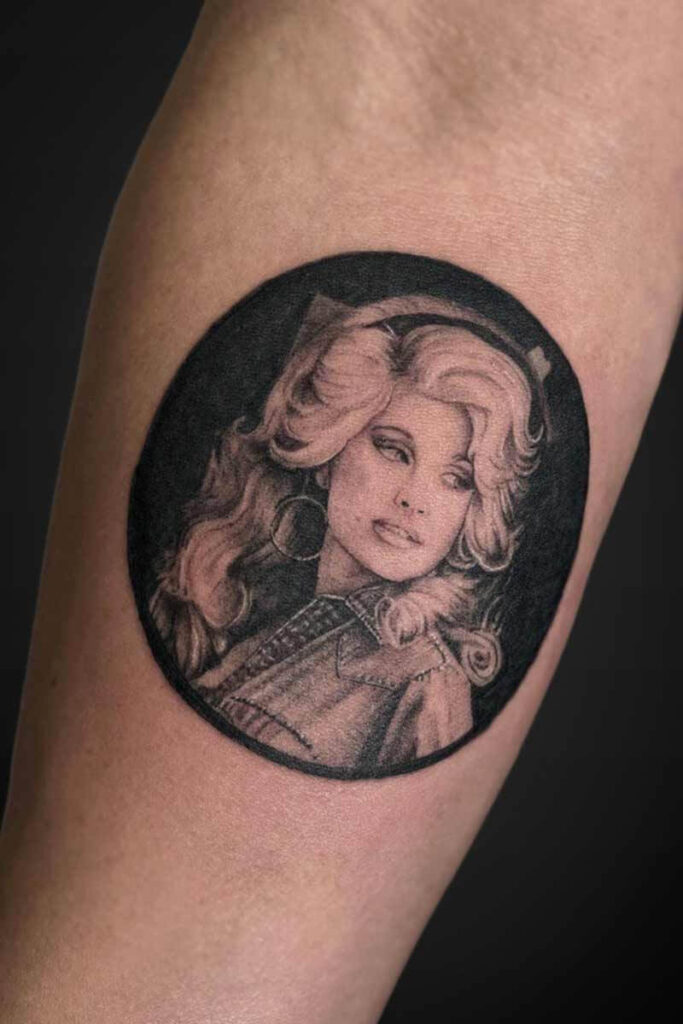 Atticus Tattoo| Black and grey realism tattoo of a portrait of Dolly Parton