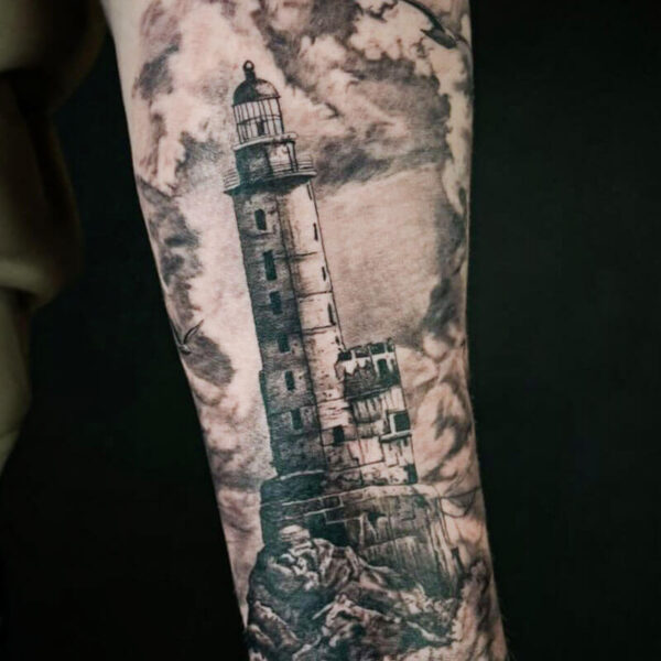 Black and Grey Realism Tattoo- Lighthouse Atticus Tattoo| Black and grey realism tattoo of a lighthouse and clouds