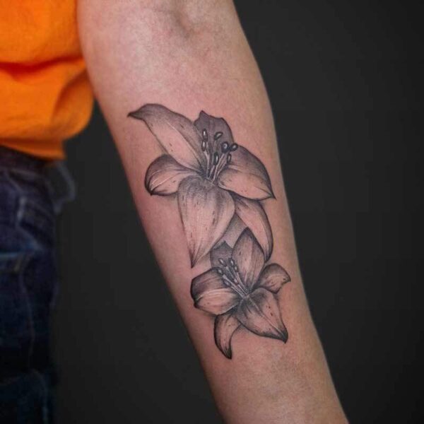 Atticus Tattoo| Realism tattoo| Black and grey tattoo| Lily| Black and grey realism tattoo of two lilies