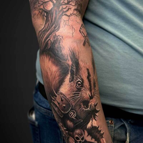 Black and Grey Realism Tattoo- Viking Squirrel Atticus Tattoo| Black and grey realism tattoo of a squirrel in viking armour with a tree behind it