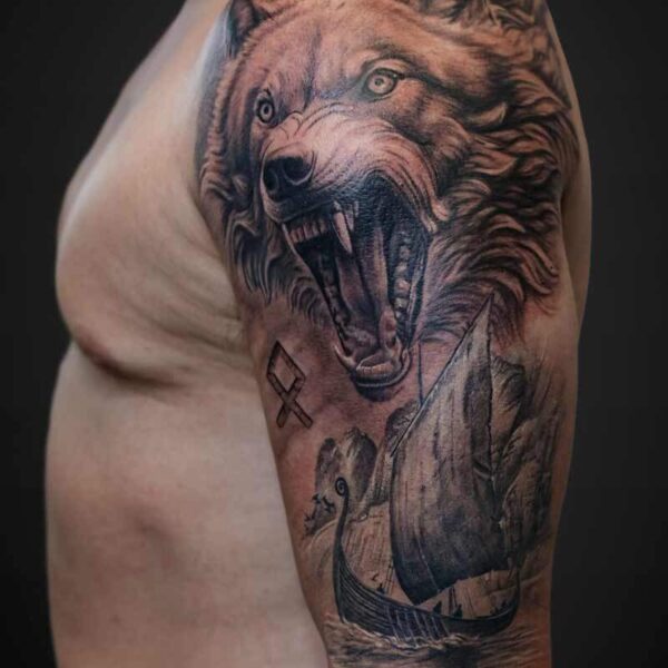Black and Grey Realism Tattoo- Wolf and Viking Ship Atticus Tattoo| Black and grey realism tattoo of a wolf with a viking ship