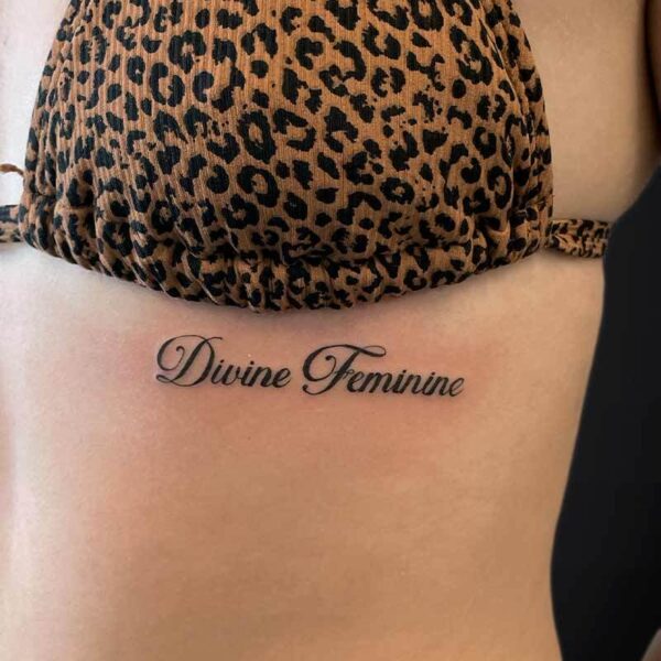 Atticus Tattoo| Feminine tattoo| Script tattoo| Tattoo of the words "Divine Feminine"