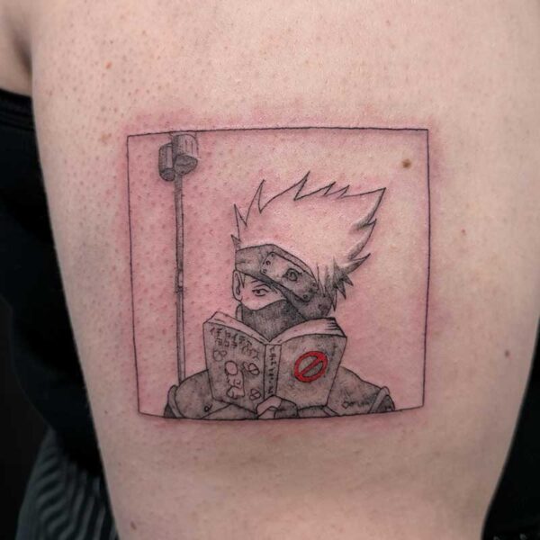 Tattoo of a Naruto-inspired ninja with spiky hair and headband, reading a book inside a framed square on the upper arm.