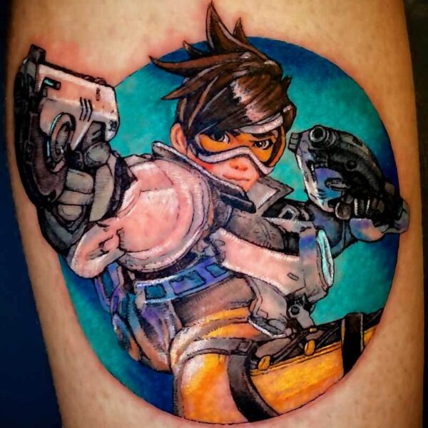 Colorful tattoo of a female video game character in orange and brown combat gear with goggles, posed mid-action against a teal circle background.