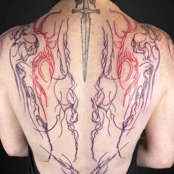 Back view of a person with a large, symmetrical tattoo: a dagger centered along the spine with ornate black linework and red shading along the shoulder blades, extending across the upper back in a wing-like pattern.