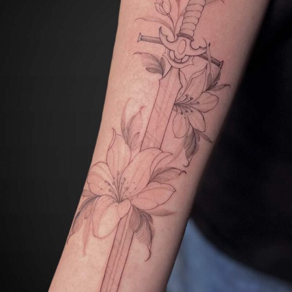 Line-drawn tattoo of a dagger entwined with blooming lilies along a forearm.