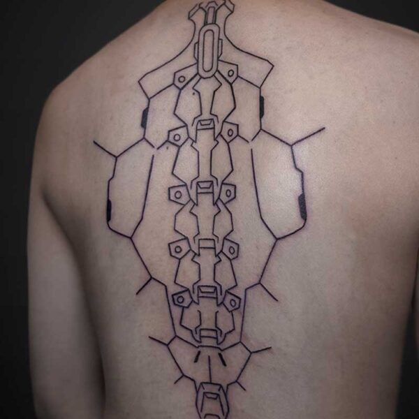 Back view of a person with a large geometric tattoo running down the spine, featuring interlocking hexagonal panels and a central vertical motif resembling an exoskeleton armor.