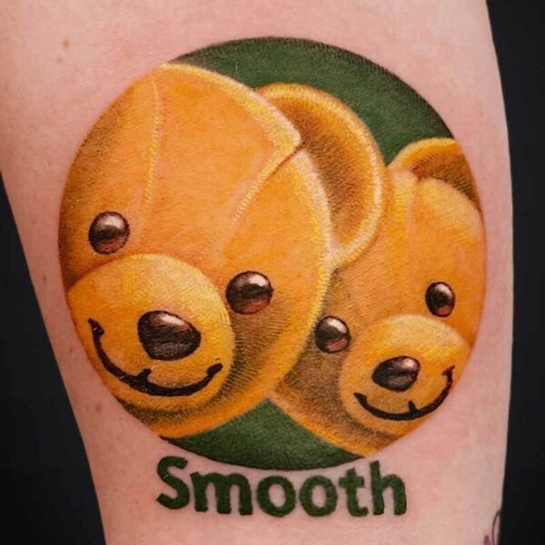 Tattoo design of two orange smiling bears inside a green circle with the word 'Smooth' beneath.