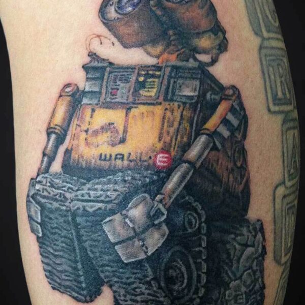 Tattoo of WALL·E the robot standing on rocky ground with his yellow body and expressive binocular eyes.