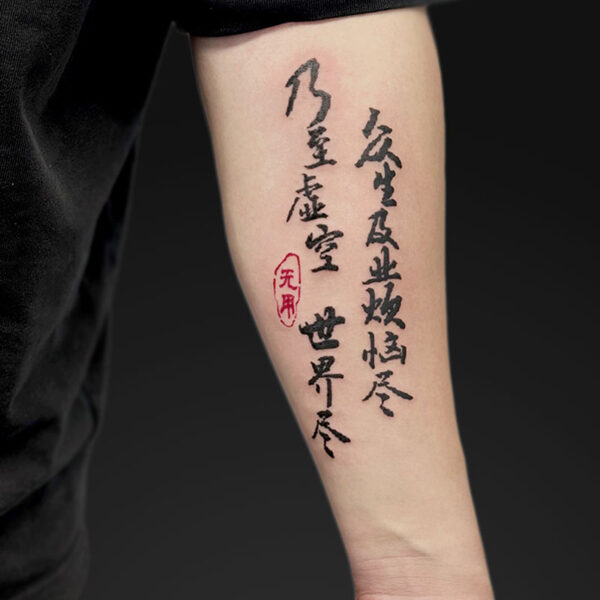 Forearm tattoo with vertical black calligraphy and a red seal stamp on the inner forearm.
