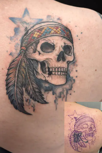 Color tattoo of a skull wearing a patterned headband, with a long feather and blue watercolor splash behind it.