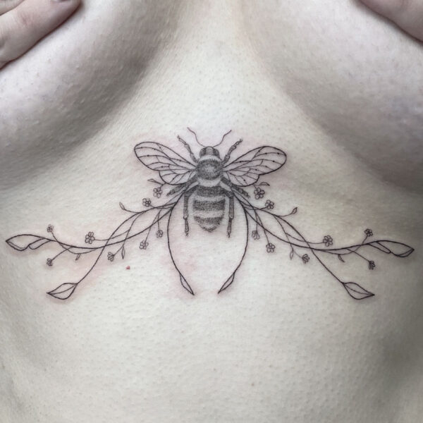 Delicate line tattoo of a bee centered on the back of the neck, with a floral vine extending left and right and small blossoms along the stems.
