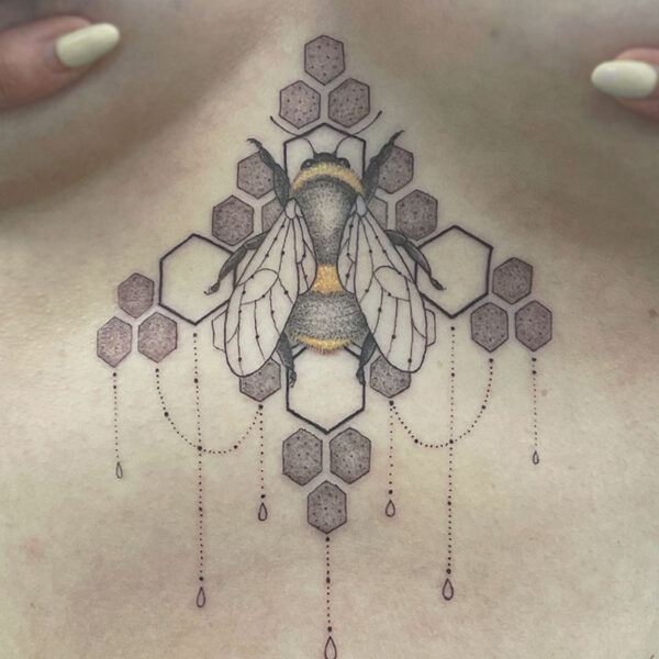 Detailed bee tattoo centered on the chest with honeycomb hexagons and hanging bead chains