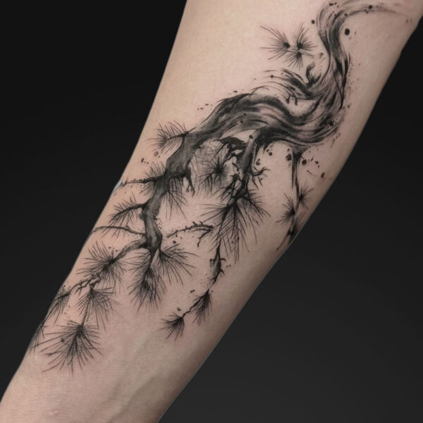 Forearm tattoo of sweeping black ink roots and wispy branches forming a wave-like pattern on the skin.