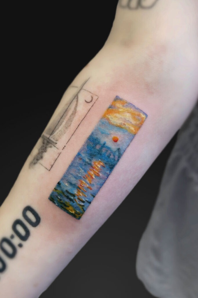 Forearm tattoo: a vertical rectangular watercolor scene of a sunset over the sea with blue water and orange sun, plus the word Hawaii, beside a rough black outline resembling a window.