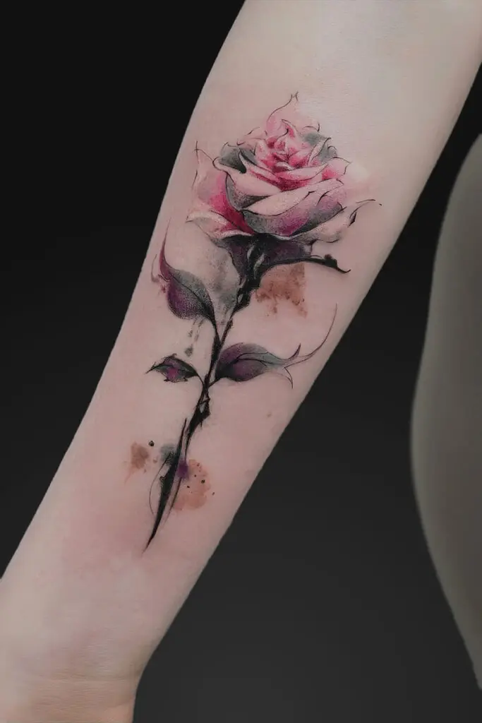 Watercolor pink rose tattoo on forearm with a black stem and subtle color washes.
